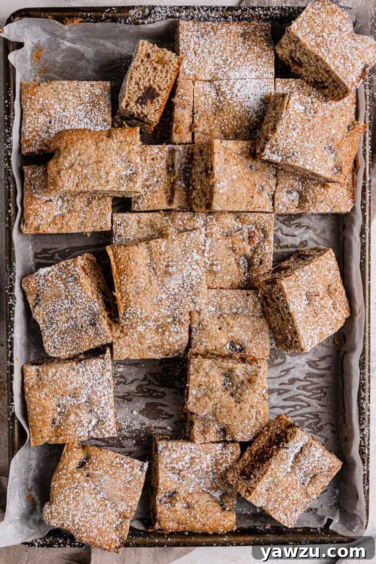 Date bars cut into neat squares on a baking pan, ready to be served or stored.