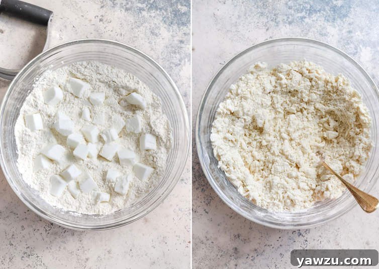 Pastry dough being mixed by hand in a clear glass bowl, showcasing its crumbly texture.