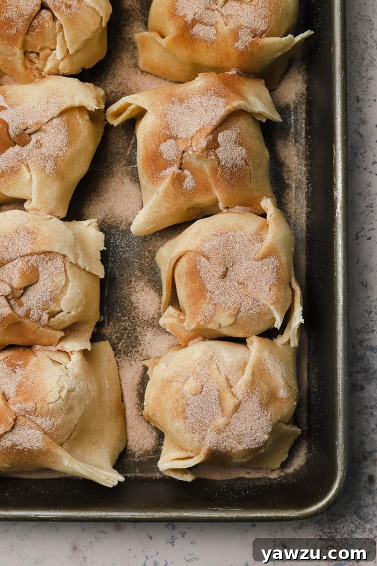 Assembled apple dumplings, neatly arranged in a glass baking pan before baking.