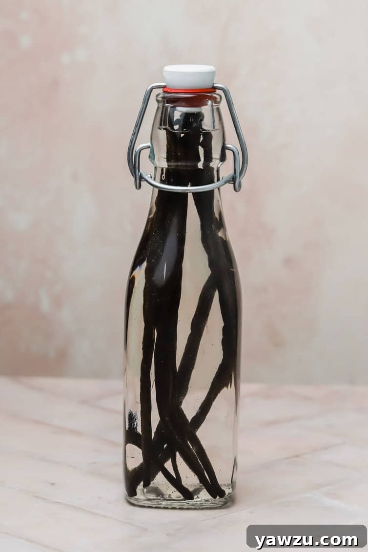 Glass bottle filled with vanilla beans and vodka.