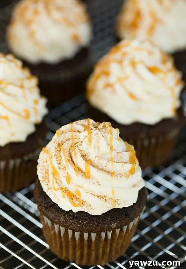 Close-up of a Pumpkin Spice Latte Cupcake with thick, creamy frosting and caramel drizzle.