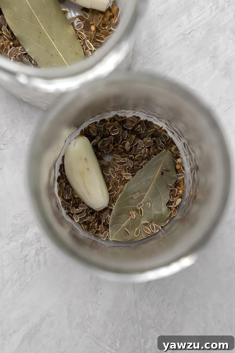Dill seed, bay leaves and garlic clove in the bottom of a jar.