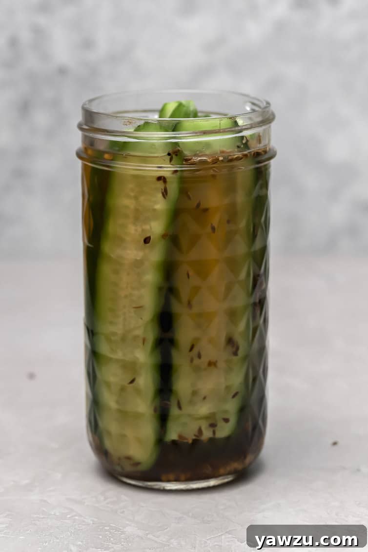 A jar of dill pickles without the lid on.