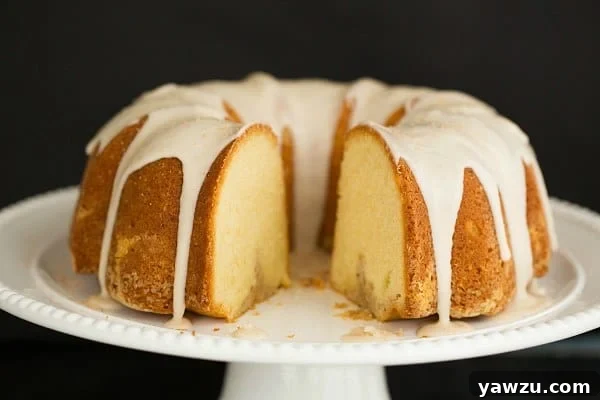 Close-up of Eggnog Bundt Cake showing its moist crumb and elegant shape, topped with a luscious rum icing.
