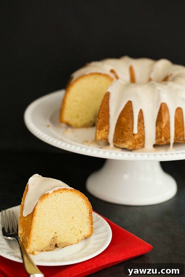 Slice of Eggnog Bundt Cake on a plate, showcasing the rum-spiced swirl within and the generous rum icing on top.