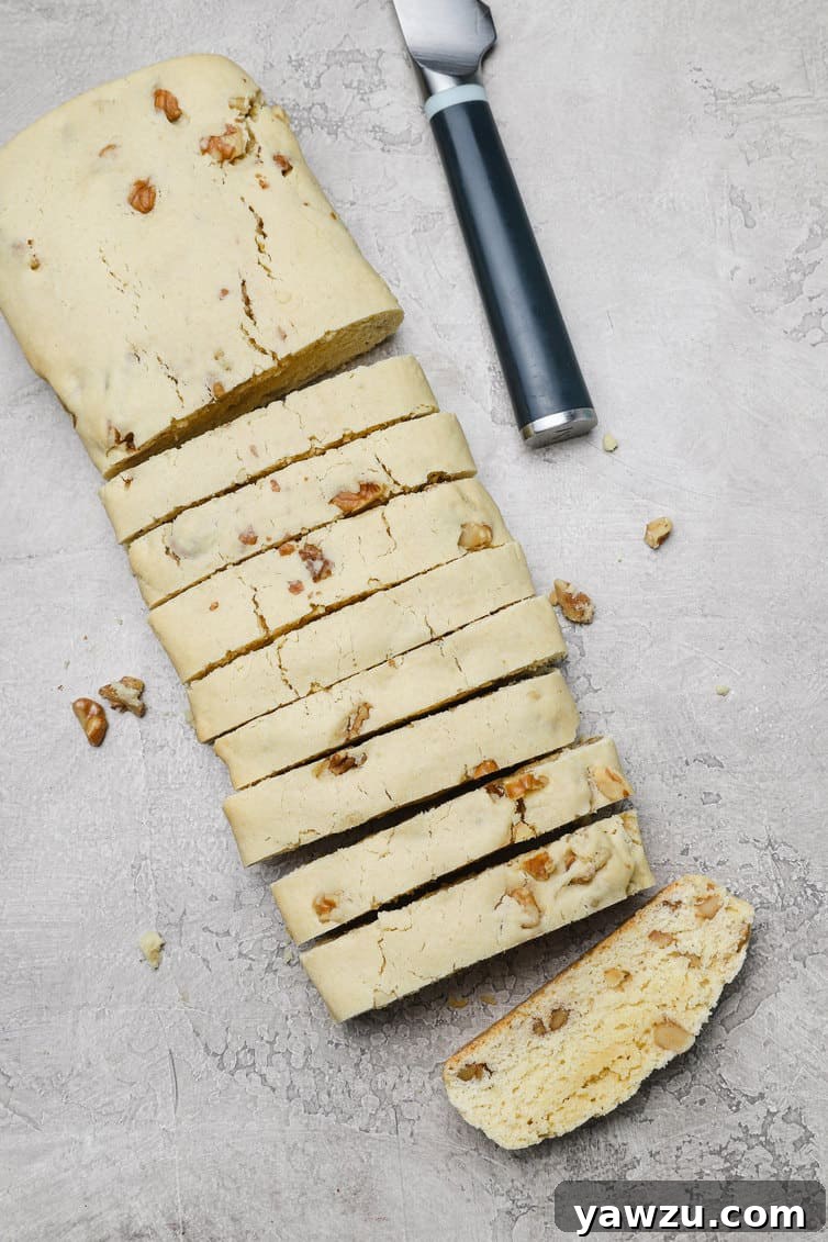 An overhead view of one baked biscotti log, expertly sliced diagonally into perfect ½-inch pieces.