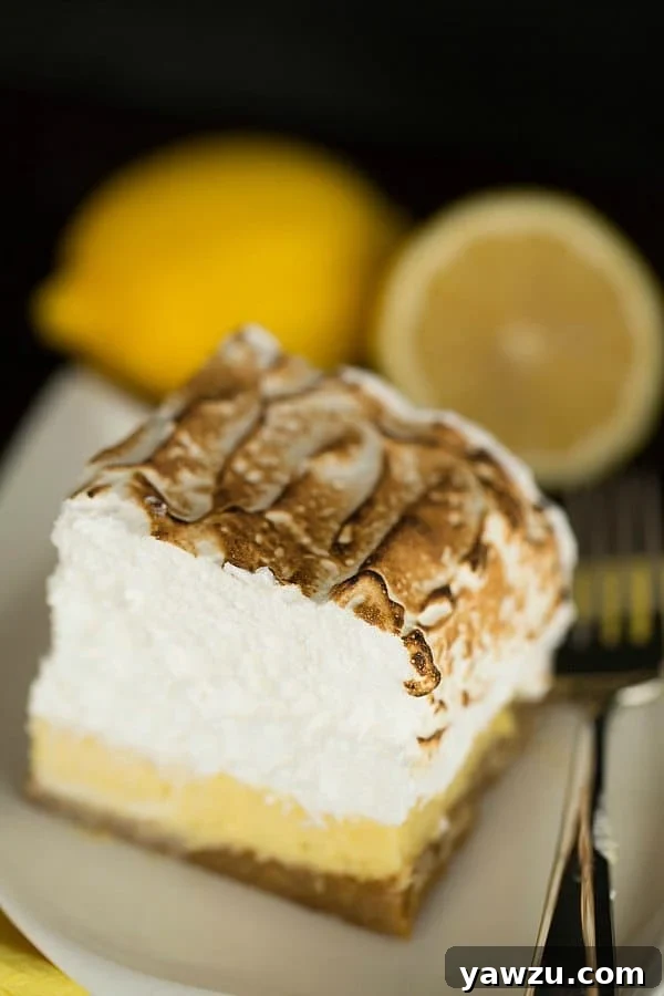 A close-up of delicious Lemon Meringue Bars, showcasing the layers of crust, filling, and fluffy meringue.