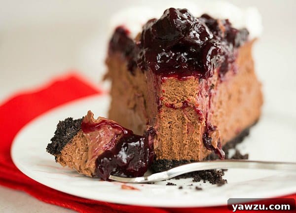 Overhead shot of a full Black Forest Cheesecake with cherry topping