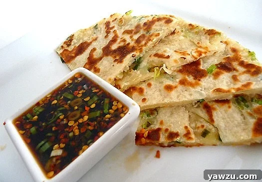 Scallion pancakes with a ginger dipping sauce on a white plate.