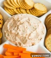 A delicious bowl of creamy Sun-Dried Tomato Dip, garnished with fresh herbs