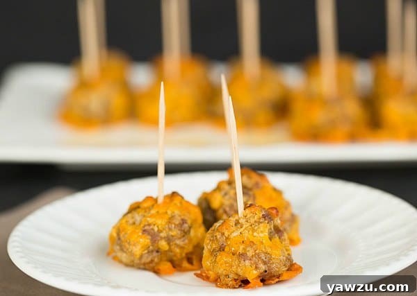 Platter of warm Sausage Cheddar Bites with toothpicks, ready to serve as a party appetizer.