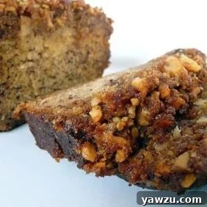 Loaf of bananas foster banana bread with 2 slices of bread on a white plate.