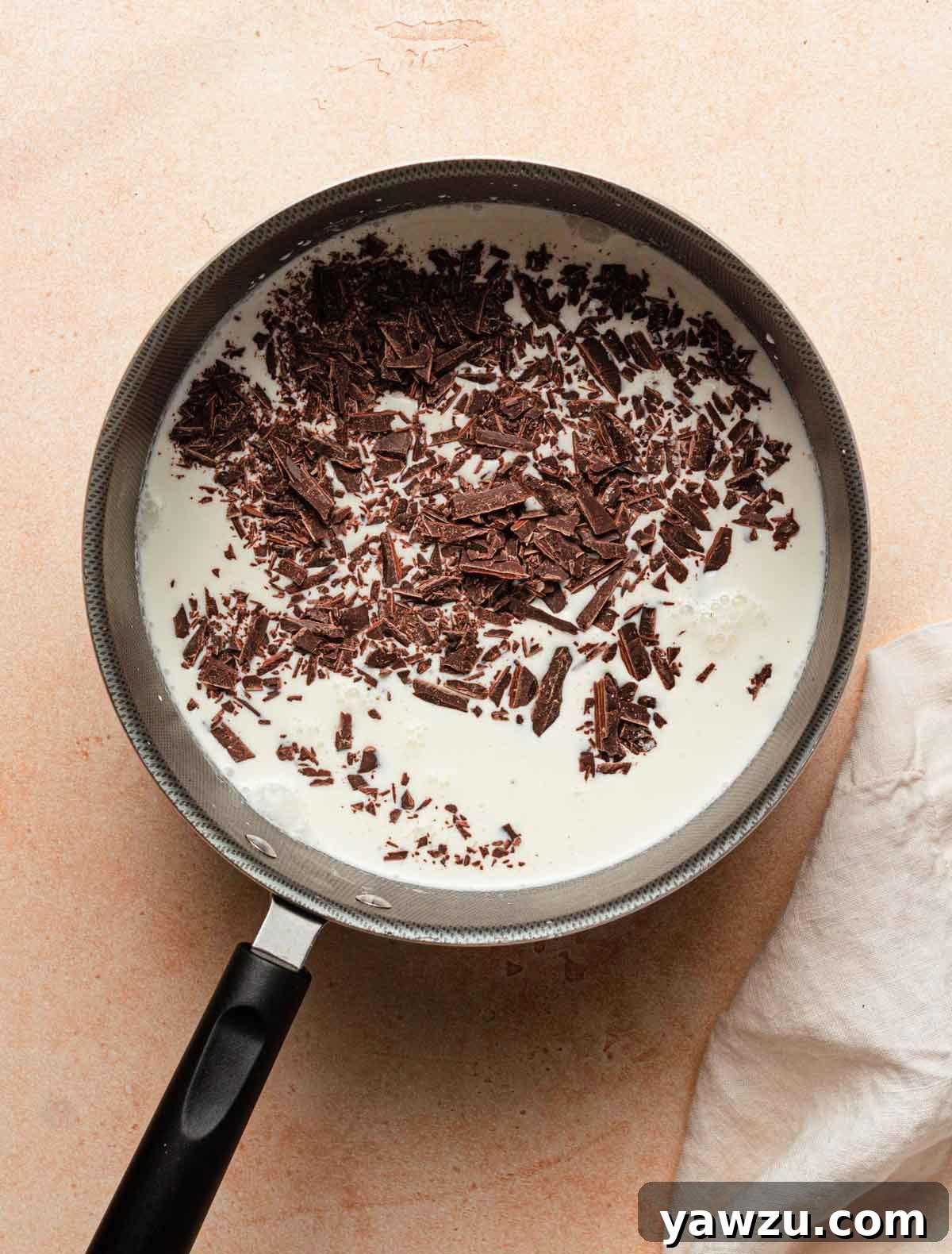 Saucepan with milk and chopped chocolate.