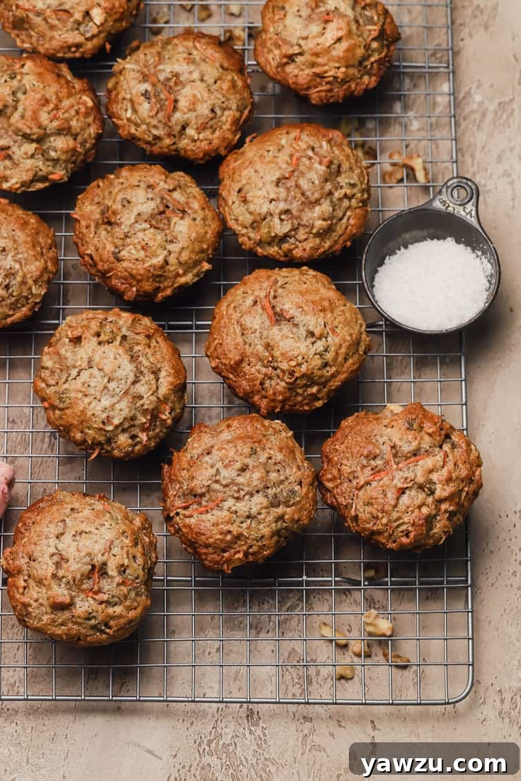 Freshly baked Morning Glory Muffins cooling on a wire rack, showcasing their golden-brown tops and inviting texture.