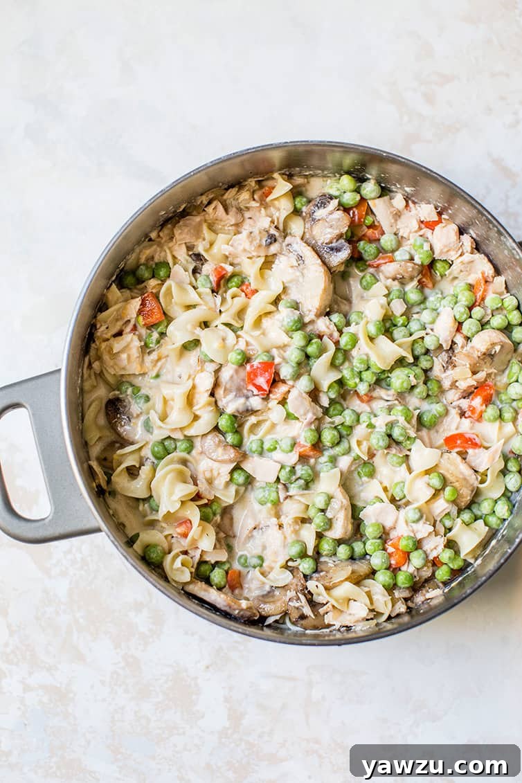 The rich and creamy tuna noodle casserole mixture, prepared and ready to be transferred into a baking dish for its final bake.