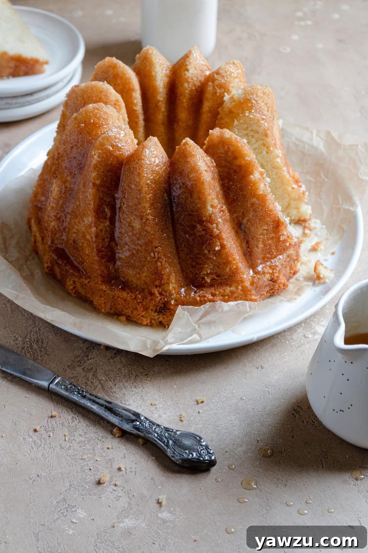 A Bundt style butter cake on a serving plate, showcasing its golden crust.