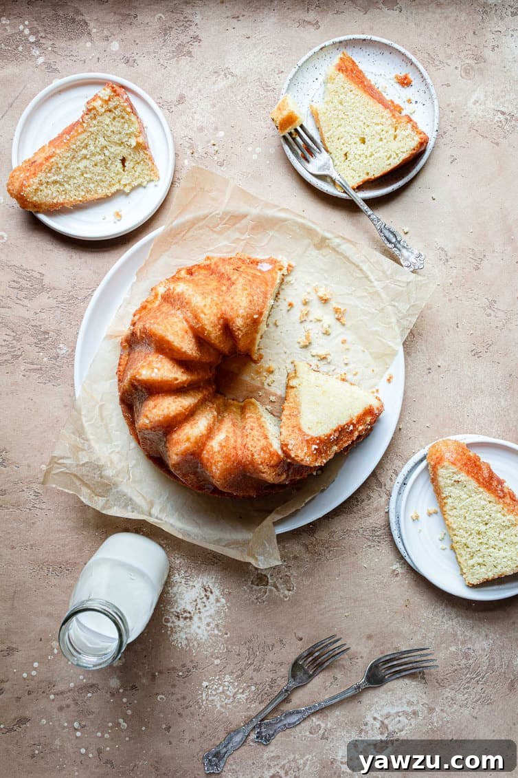 Overhead photo of a whole butter cake with three slices artfully arranged on plates around it.