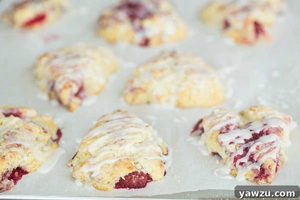 Close-up of freshly baked Meyer Lemon-Raspberry Scones with a lemon glaze.