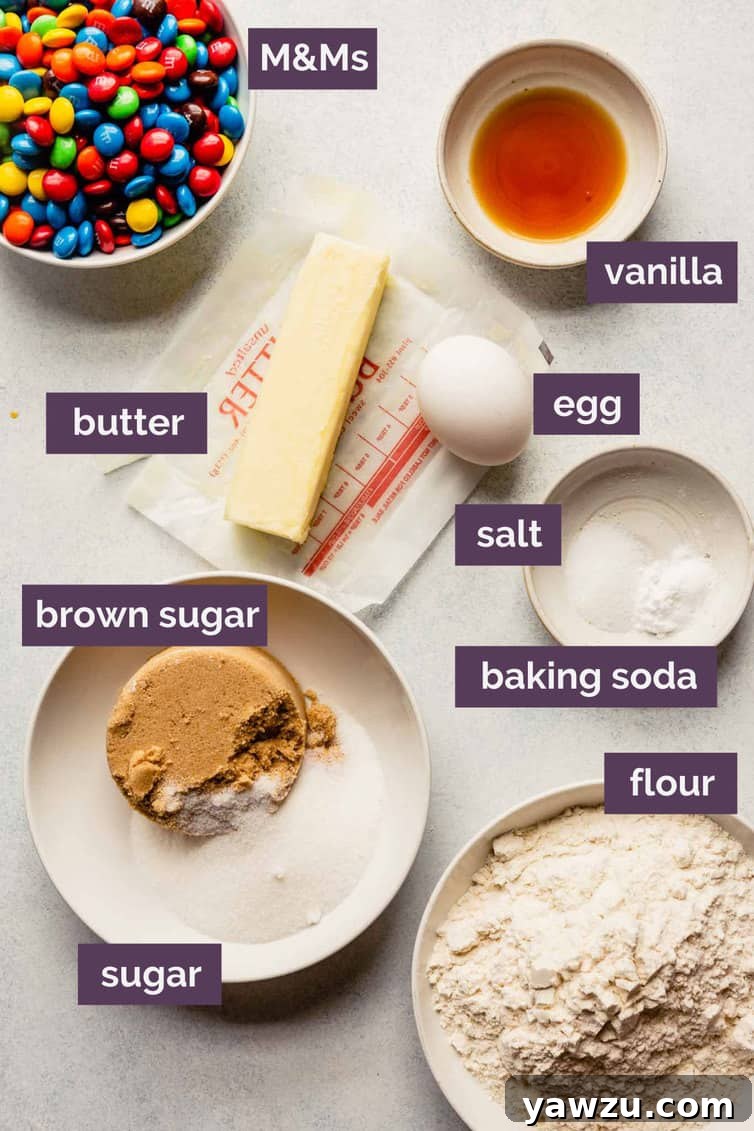 Ingredients for M&M cookies prepped in individual bowls and clearly labeled for easy baking.