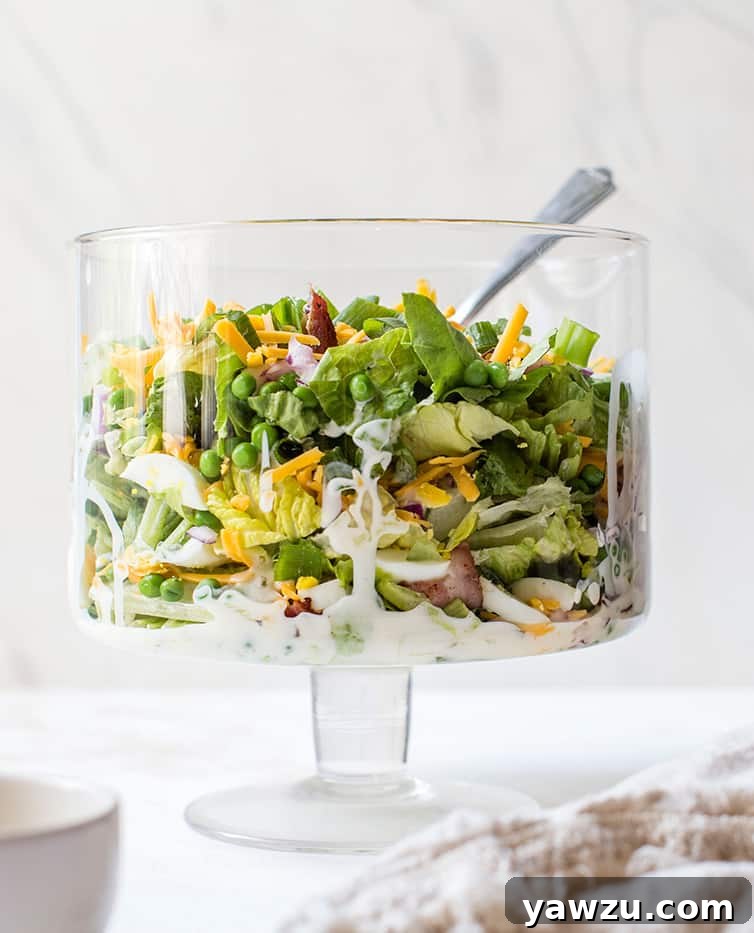 A glass trifle bowl with seven layer salad.