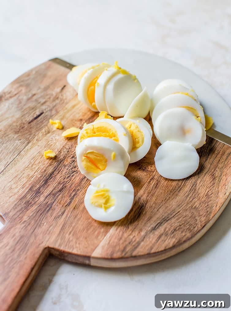 Sliced hard boiled eggs on a cutting board.