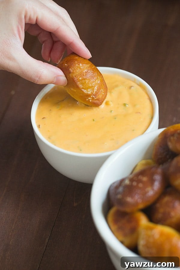 A close-up shot of fluffy, golden soft pretzel nuggets generously sprinkled with coarse salt.