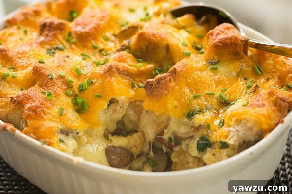 Serving slice of Cheesy Bacon, Mushroom & Spinach Breakfast Strata