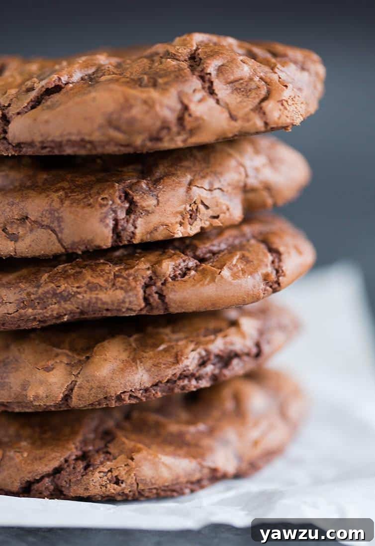A big stack of Better-Than-Brownies Chocolate Cookies on a cooling rack, showcasing their rich color and texture.