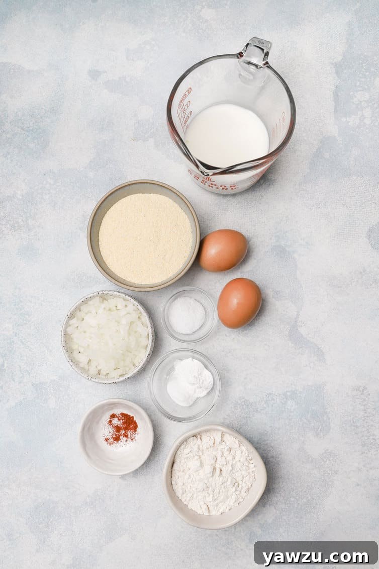 Fresh ingredients for making hush puppies, prepped and arranged in various bowls on a countertop.