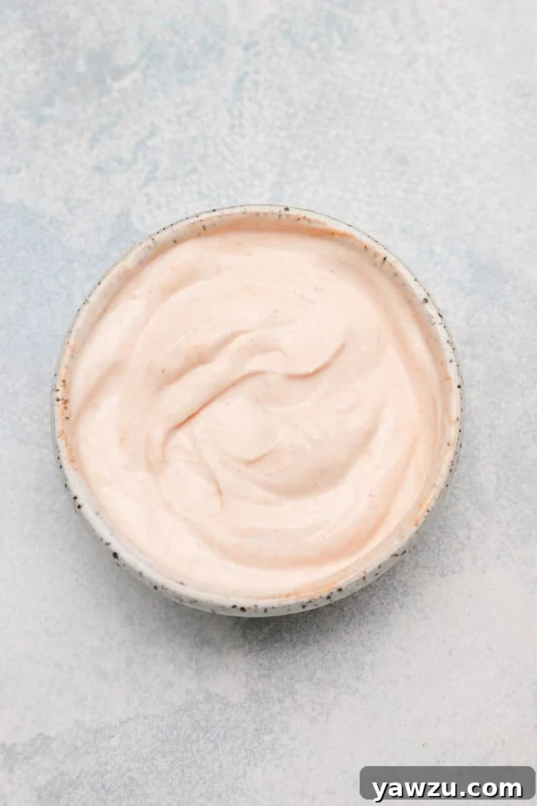 A small bowl filled with homemade spicy dipping sauce, perfect for hush puppies.