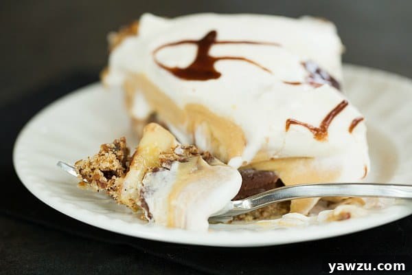 Close-up of a slice of Chocolate-Peanut Butter Banana Cream Pie with Pretzel Crust, showing layers.