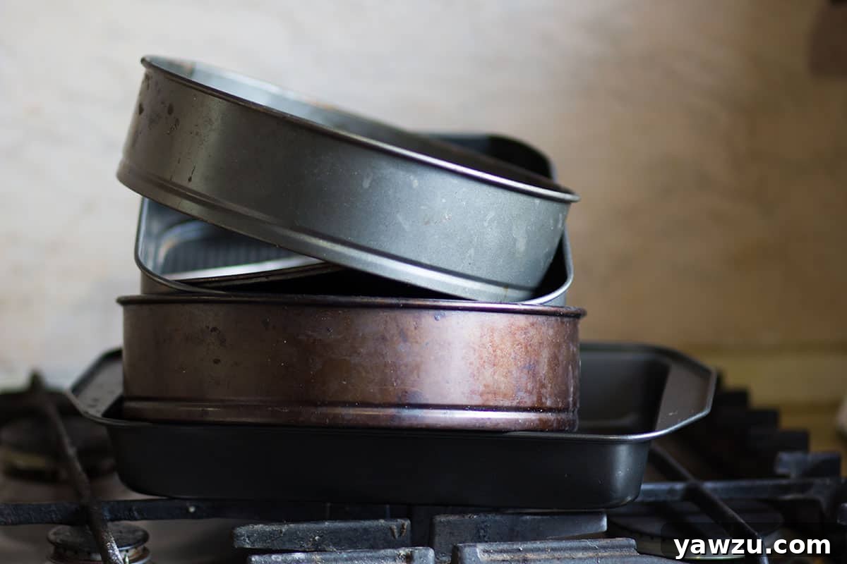 Baking pans stacked on a stove burner, symbolizing essential baking tools.