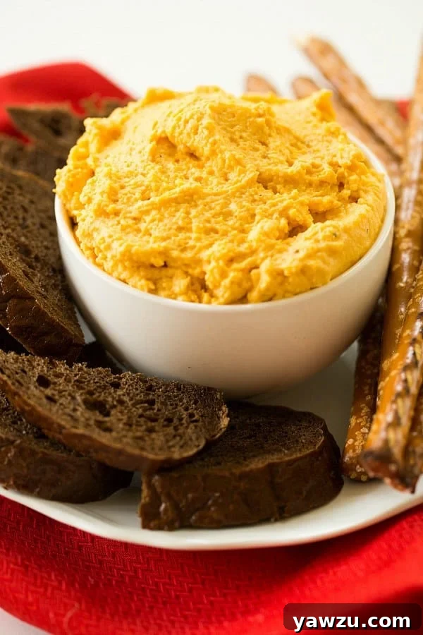 Creamy Oktoberfest German Beer Cheese Spread served with a large soft pretzel, perfect for dipping