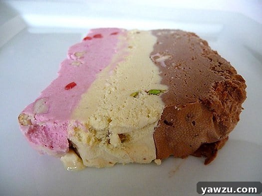 Slice of spumoni ice cream terrine on a white plate.