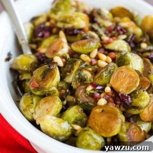 A top-down view of Brussels Sprouts with Pancetta, Cranberries & Pine Nuts in a skillet, freshly cooked and ready to serve.