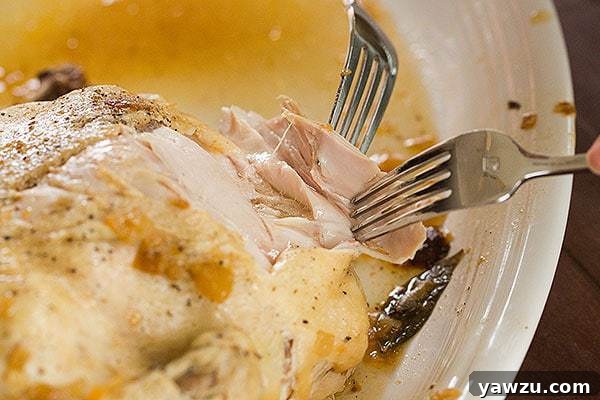 Closeup of the incredibly tender and juicy Slow Cooker Whole Roasted Chicken, ready to be carved and served.