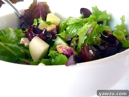 A vibrant Signature Salad in a white bowl, ready to be enjoyed.