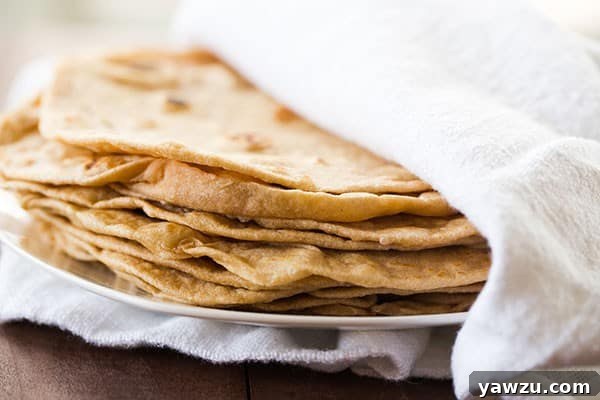 Close-up of a stack of fluffy, freshly made flour tortillas, showing their inviting texture.