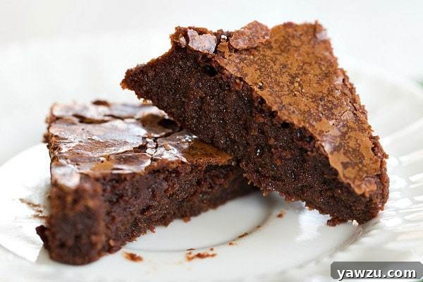Three squares of fudgy Guinness Brownies, some with green sprinkles, on a wire rack cooling. Perfect St. Patrick's Day dessert.