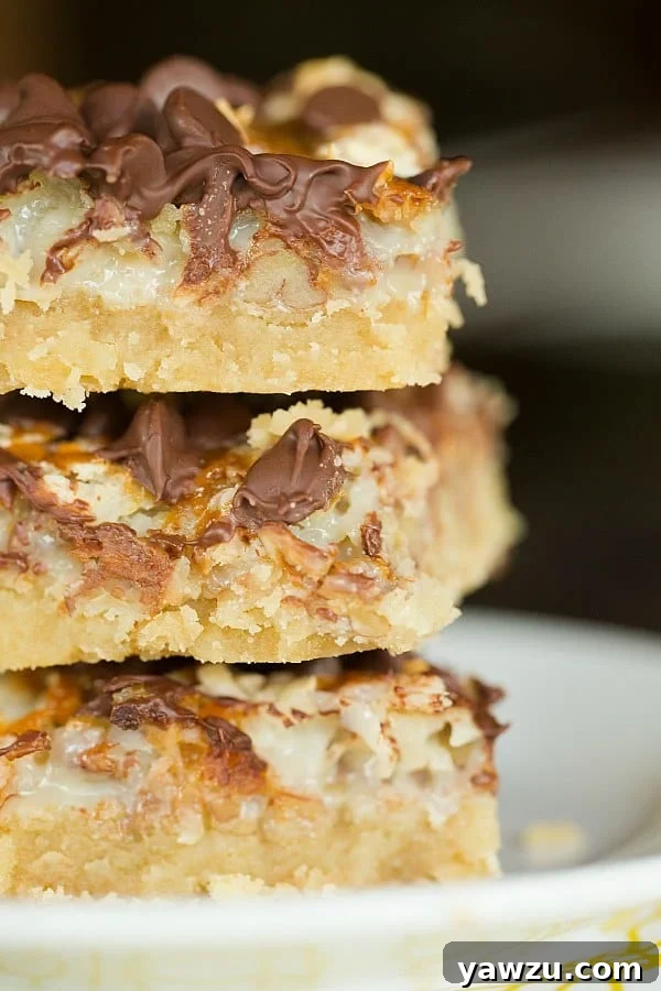 Homemade Ultimate Magic Bars - Layers of brown sugar shortbread, gooey sweetened condensed milk, crunchy pecans, shredded coconut, rich chocolate chips, and swirls of caramel. A perfect treat for any occasion!