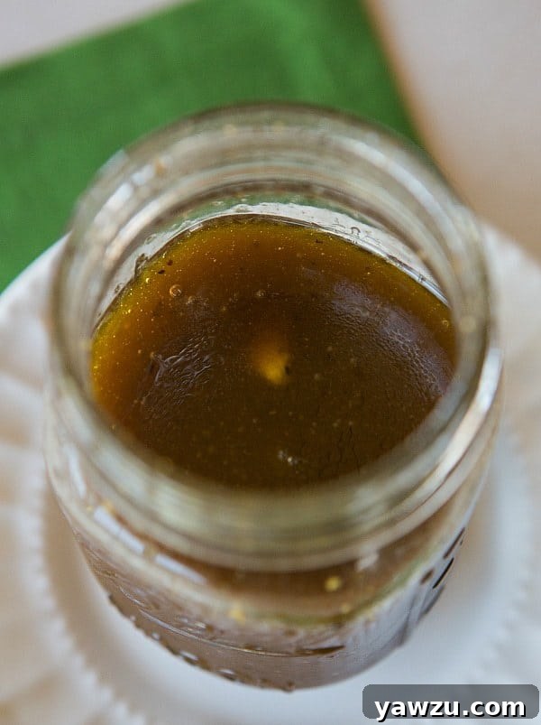 A vibrant green salad drizzled with golden Honey Balsamic Vinaigrette, illustrating its fresh appeal.