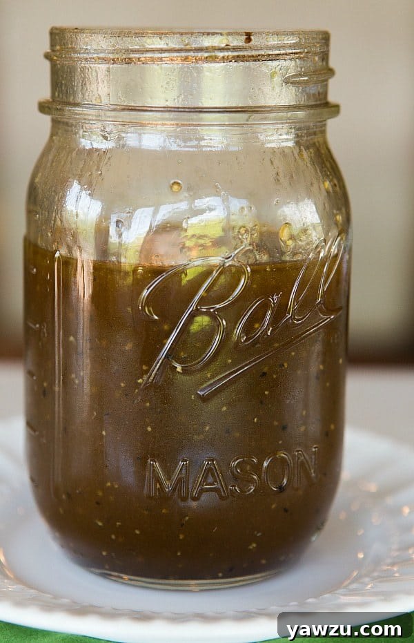 A close-up of the Honey Balsamic Vinaigrette in a glass jar, showing its rich texture and color, ready for storage.