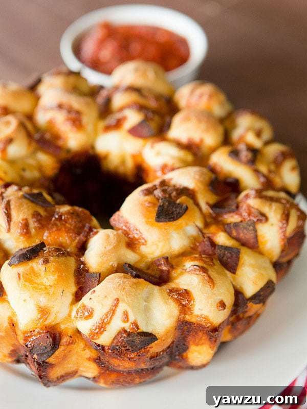Irresistible Pepperoni Pizza Monkey Bread with a side of zesty dipping sauce, perfect for sharing.