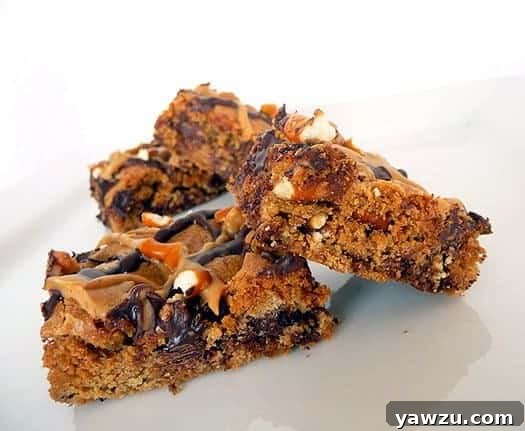 Chocolate chip and pretzel cookie bars on a white plate.
