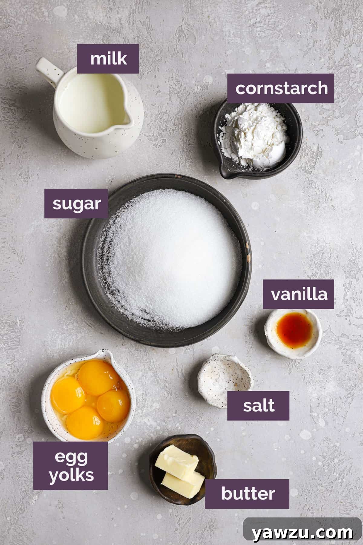 A grey counter with the ingredients for pastry cream and purple labels telling what the ingredients are.