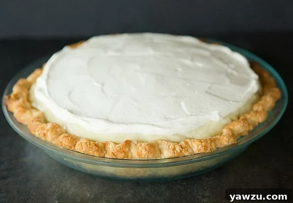 Close-up of a slice of banana cream pie revealing layers of golden crust, fresh bananas, and creamy filling