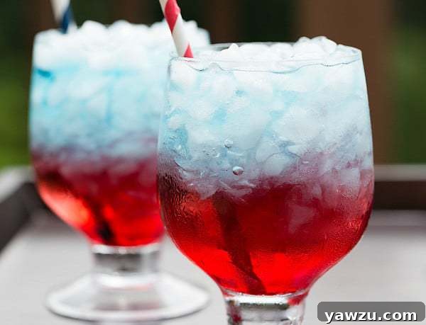 A close-up view of a perfectly layered Red, White & Blue drink, showcasing the distinct separation of colors. Ideal for summer parties and patriotic celebrations.