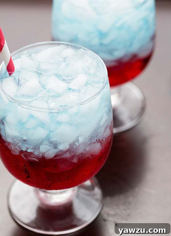 A festive red, white, and blue layered drink with a straw, ready for serving at a party. The perfect patriotic beverage for celebrations.
