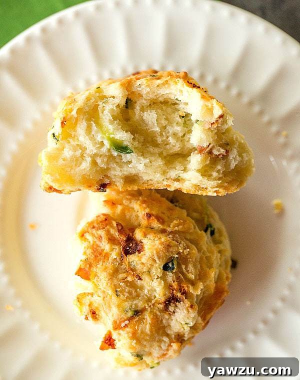 Platter of golden-brown Cheesy Zucchini and Sun-Dried Tomato Scones, ready to serve.