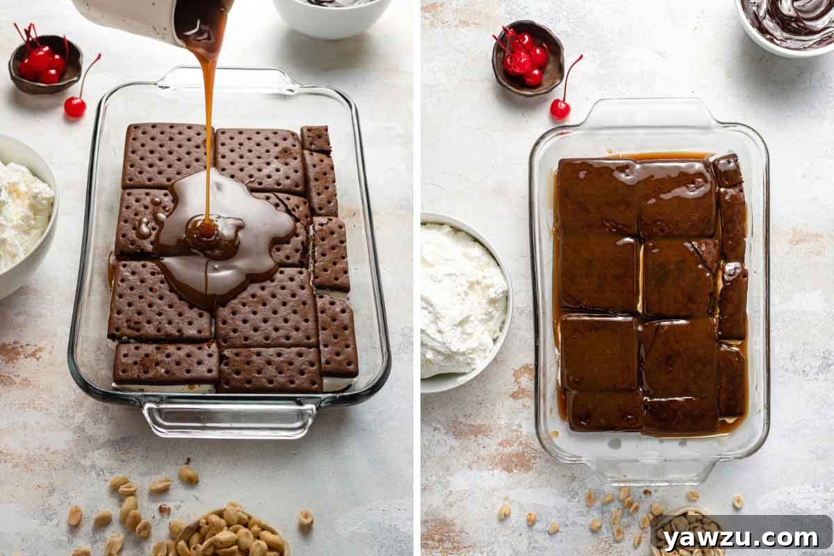 Hands pouring rich, golden caramel sauce over a perfectly arranged layer of ice cream sandwiches in a clear glass baking dish, preparing the first decadent layer of the cake.